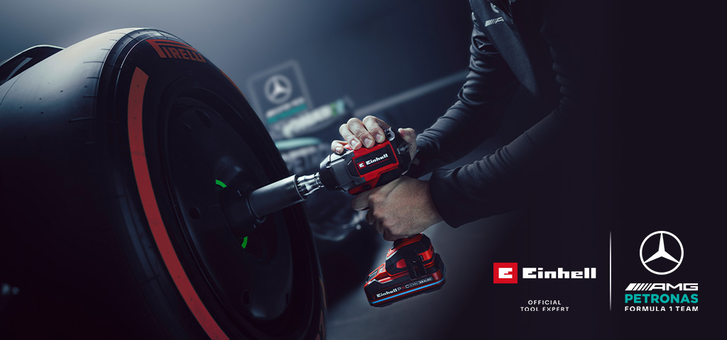 Einhell cordless impact wrench in use on a car wheel, with Mercedes-AMG Petronas Formula One Team branding and partnership logo